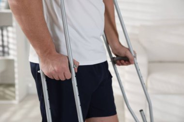 Evde koltuk değneği kullanan bir adam, yakın plan.