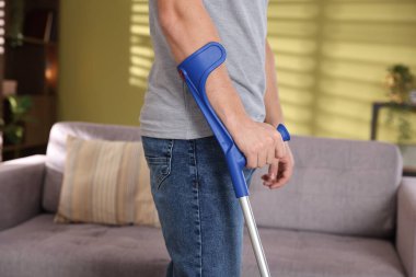 Evde dirsek değneği kullanan adam, yakın plan.