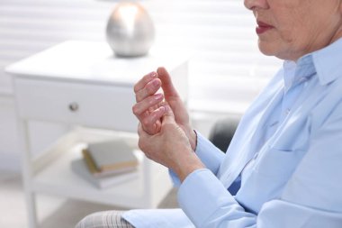 Romatizma belirtileri. Evde avuç içi ağrısı çeken son sınıf öğrencisi kadın, yakın çekim. Metin için boşluk