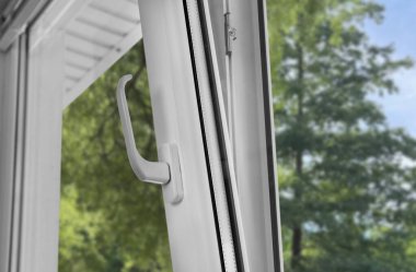 Pencereyi havalandırma için aç, kapat. Yeşil ağaçlar, camdan manzaralı