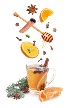 Sıcak şarap tarifi. Baharatlar ve diğer malzemeler cam bardağa dökülüyor ve beyaz arka planda içecek var.