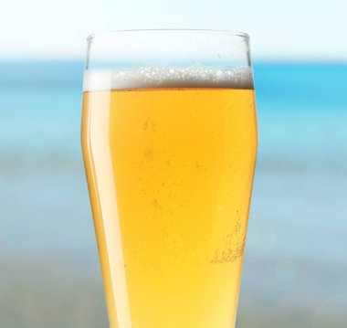 Deniz kenarında bir bardak bira, yakın plan. Tazeleyici yaz içeceği