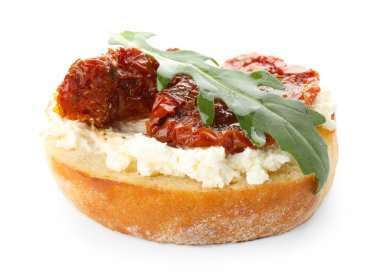 Krem peynirli nefis bruschetta, güneşte kurutulmuş domates ve beyaz üzerine izole edilmiş roka.