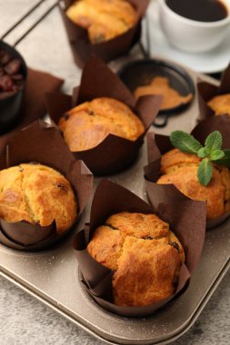 Üzümlü lezzetli kekler, nane şekeri ve kahve gri masada, yakın plan.