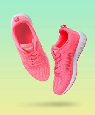 Renk gradyan arka planında havada pembe spor ayakkabılar