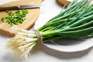 Taze taze taze soğanlar beyaz ahşap masada, yakın plan.