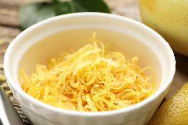 Limon aromalı kase ve ahşap masada taze meyve, yakın plan.