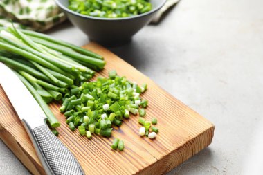 Açık gri masada yeşil soğan ve bıçak kes, yakın plan. Metin için boşluk