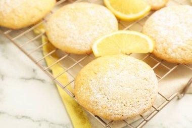 Lezzetli limonlu kurabiyeler ve beyaz mermer masada meyve dilimleri, yakın plan.