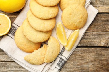 Lezzetli limonlu kurabiyeler ve ahşap masada meyve dilimleri.