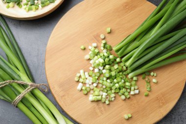 Tam ve taze yeşil soğanları gri masada, düz yatıyordu.