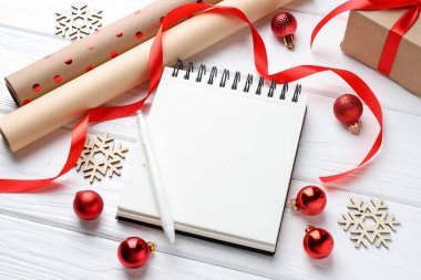 Yeni yıl hedefleri. Boş planlayıcı, kalem ve beyaz ahşap masada şenlikli bir dekor.