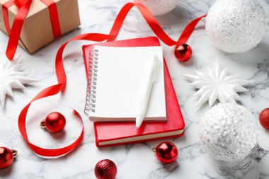 Yeni yıl hedefleri. Beyaz mermer masa üzerinde boş planlayıcı, kalem ve şenlikli dekor