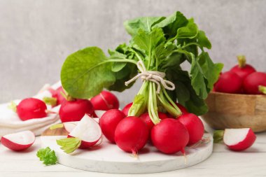 Taze taze ve turpları beyaz mermer masada gri duvara yakın çekimde.