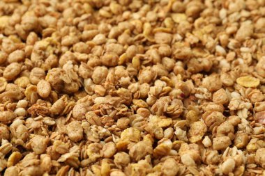 Arka planda yulaf taneleri olan lezzetli granola, yakın plan.