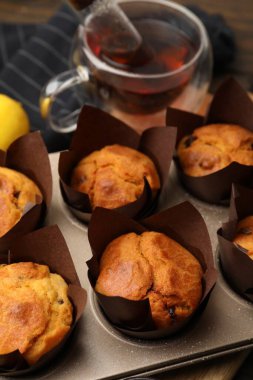 Kuru üzümlü lezzetli kekler, masada çay ve limon, yakın plan.