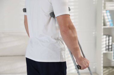 Evde koltuk değneği kullanan bir adam, yakın plan.