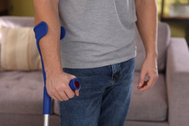 Evde dirsek değneği kullanan adam, yakın plan.