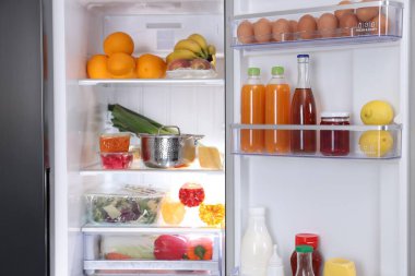 Farklı taze gıda ürünleri olan modern buzdolabı, yakın plan.