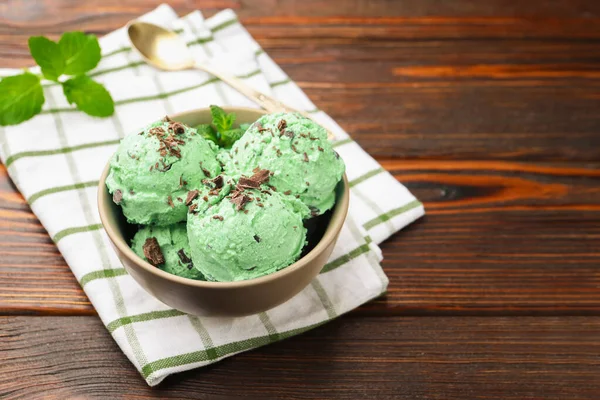Çikolata parçalı lezzetli dondurma, tahta masada kaşık ve havlu. Metin için boşluk