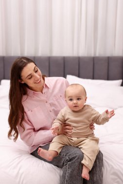 Mutlu bir anne, tatlı bebeğiyle evde yatıyor.