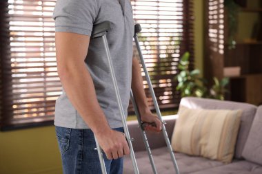 Evde koltuk değneği kullanan bir adam, yakın plan. Metin için boşluk