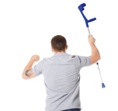 Beyaz arka planda dirsek değneği olan bir adam.