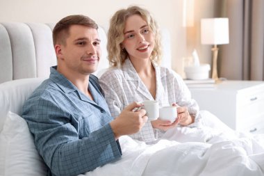 Hoş bir çift evde sıcak içeceklerin tadını çıkarıyor.