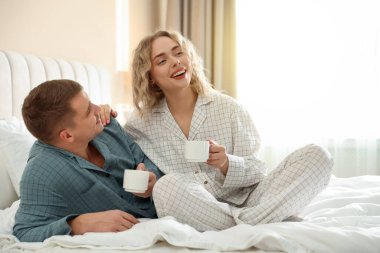 Hoş bir çift evde sıcak içeceklerin tadını çıkarıyor.