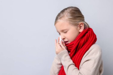 Hafif arka planda burnu akan küçük bir kız, mesaj için yer var. Soğuk Semptom