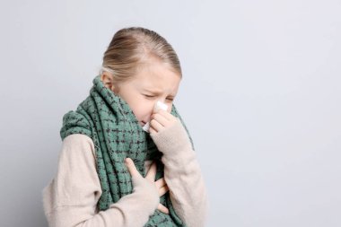 Hafif arka planda burnu akan küçük bir kız, mesaj için yer var. Soğuk Semptom