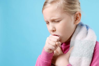 Açık mavi arka planda öksüren küçük kız, mesaj için yeri olan yakın plan. Soğuk Semptom