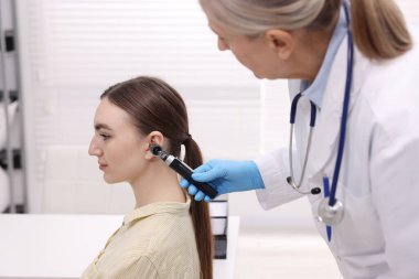 Duyma testi. Klinikte hastanın kulağını yıldız falıyla muayene eden doktor.