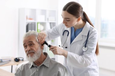 Duyma testi. Klinikte hastanın kulağını yıldız falıyla muayene eden doktor.