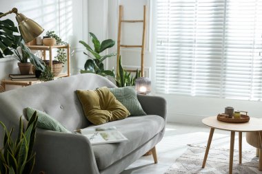 Kanepesi ve çiçekleri olan şık bir oturma odası. İç tasarım