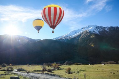 Dağların üzerinde uçan renkli sıcak hava balonları
