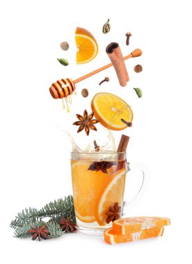 Sıcak şarap tarifi. Baharatlar ve diğer malzemeler cam bardağa dökülüyor ve beyaz arka planda içecek var.