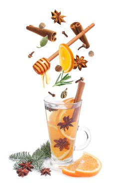 Sıcak şarap tarifi. Baharatlar ve diğer malzemeler cam bardağa dökülüyor ve beyaz arka planda içecek var.