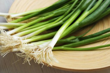 Taze taze taze soğanlar beyaz ahşap masada, yakın plan.