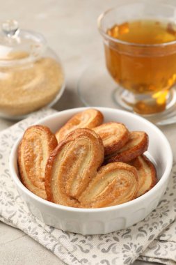 Nefis avuç içi kurabiyeler, çay ve kahverengi şeker açık gri masada, yakın plan.