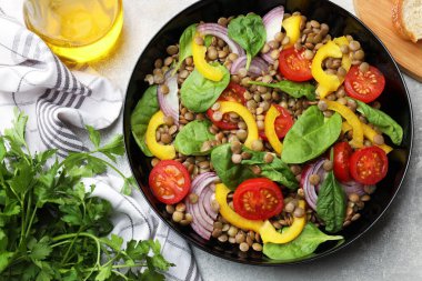 Mercimekli, sebzeli ve gri masadaki yağlı lezzetli salata.