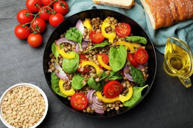 Lezzetli mercimek salatası, malzemeler ve gri desenli masada ekmek.