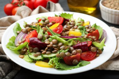 Gri masada mercimek ve sebzeli lezzetli salata, yakın plan.