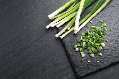 Taze yeşil soğanları siyah masaya koyun ve düz yatırın. Metin için boşluk