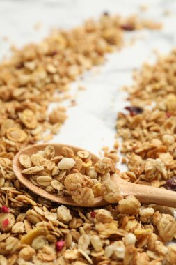 Lezzetli granola ve kaşık beyaz mermer masada, yakın plan.