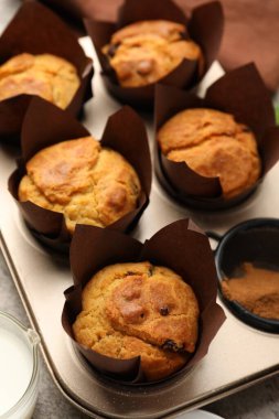 Kek tepsisinde lezzetli kekler ve masada süt, yakın plan.