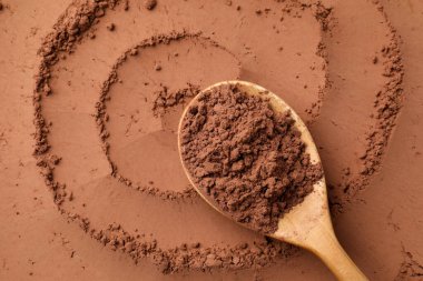 Kakao tozu ve tahta kaşık arka plan olarak, üst görünüm