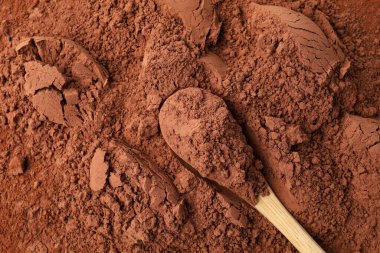 Kakao tozu ve tahta kaşık arka plan olarak, üst görünüm