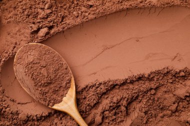 Kakao tozu ve tahta kaşık arka plan olarak, üst görünüm