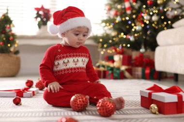 Noel Baba şapkalı şirin bir bebek, süsler ve evde hediye, mesaj için yer. Noel sezonu